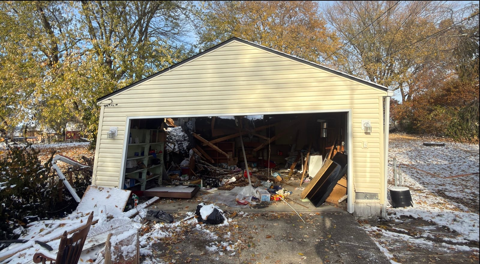 A detached garage packed to the door with stored junk and debris