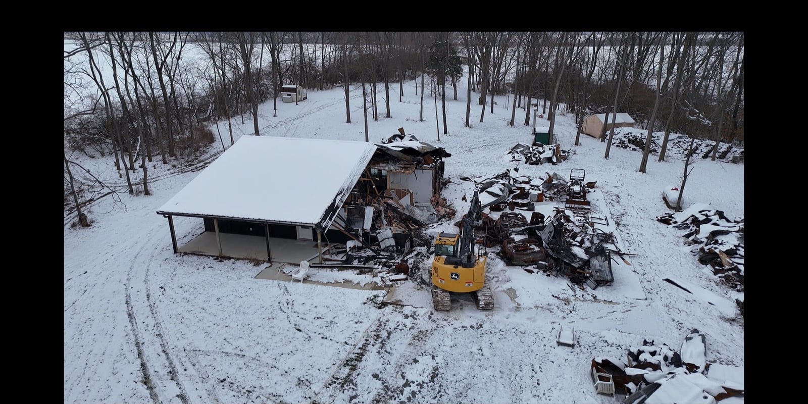 Aerial view of a collapsed snow-covered structure surrounded by debris