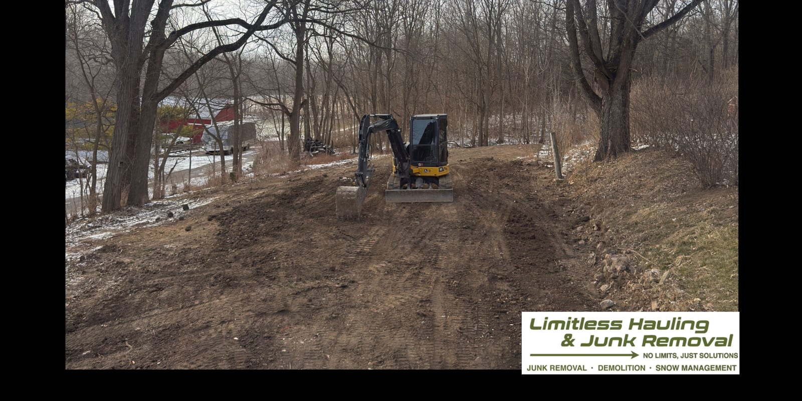 The same yard cleared, with an excavator finishing the ground