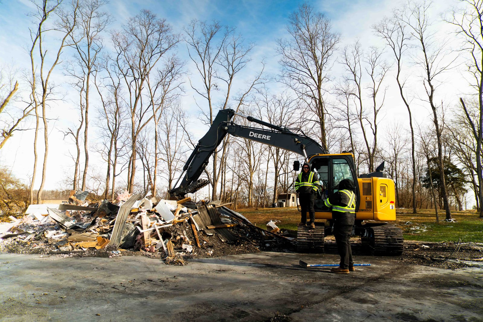 A cleared and leveled lot with a Limitless excavator and crew member at the end of a job