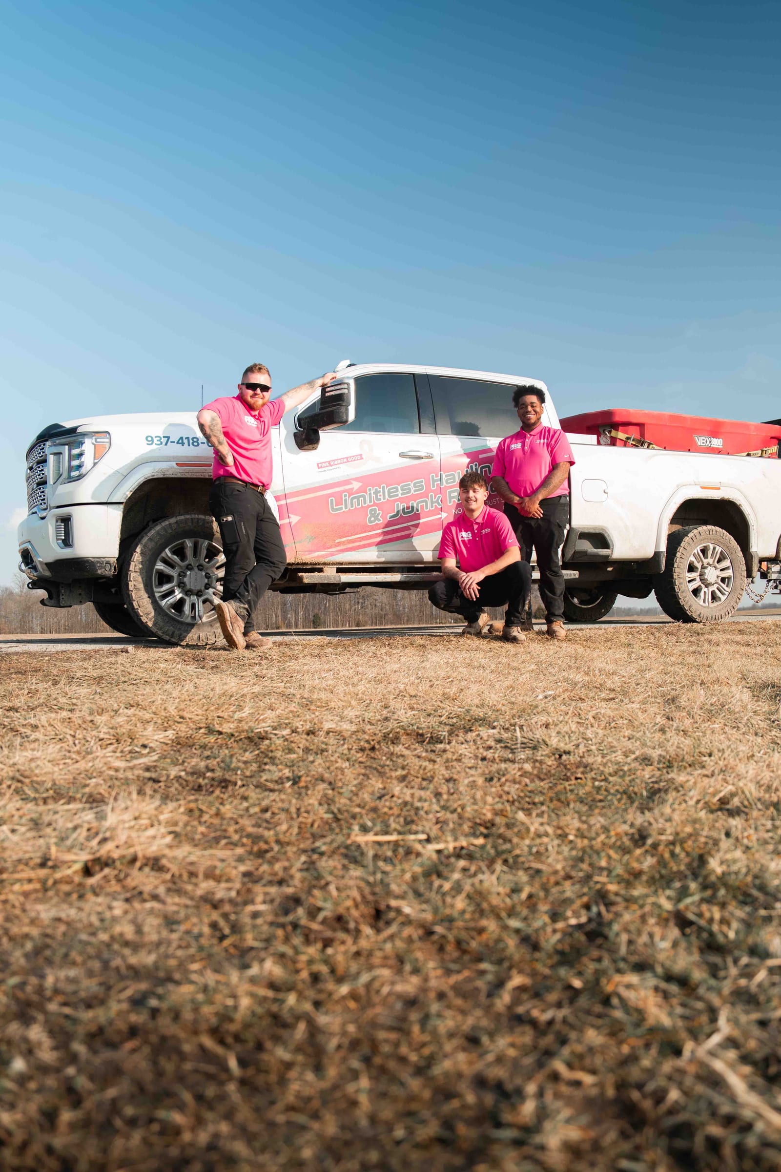 The Limitless crew standing beside a company pickup truck on a job site